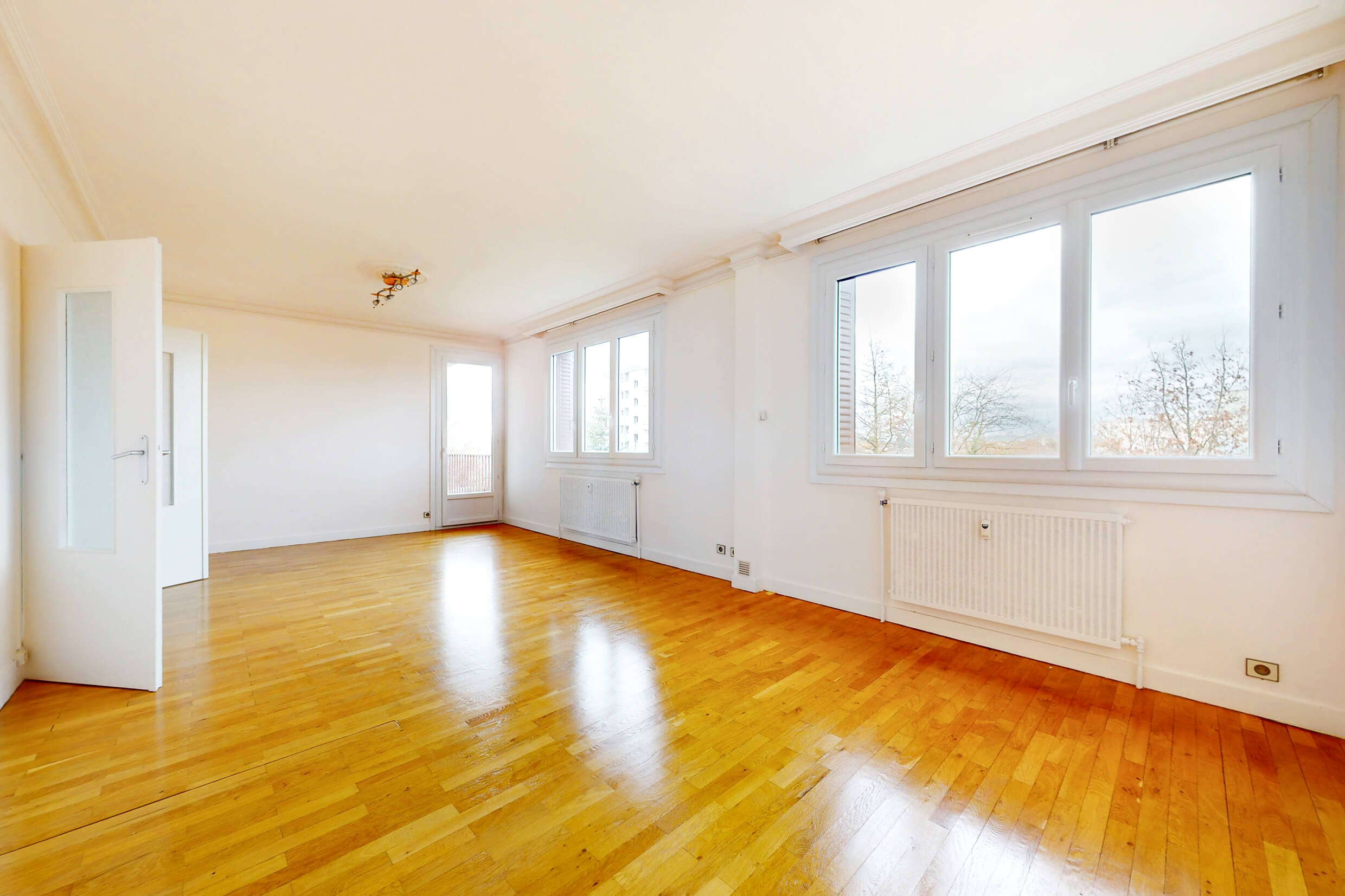 Grand salon lumineux avec parquet et accès direct au balcon – appartement en vente à Meyzieu centre