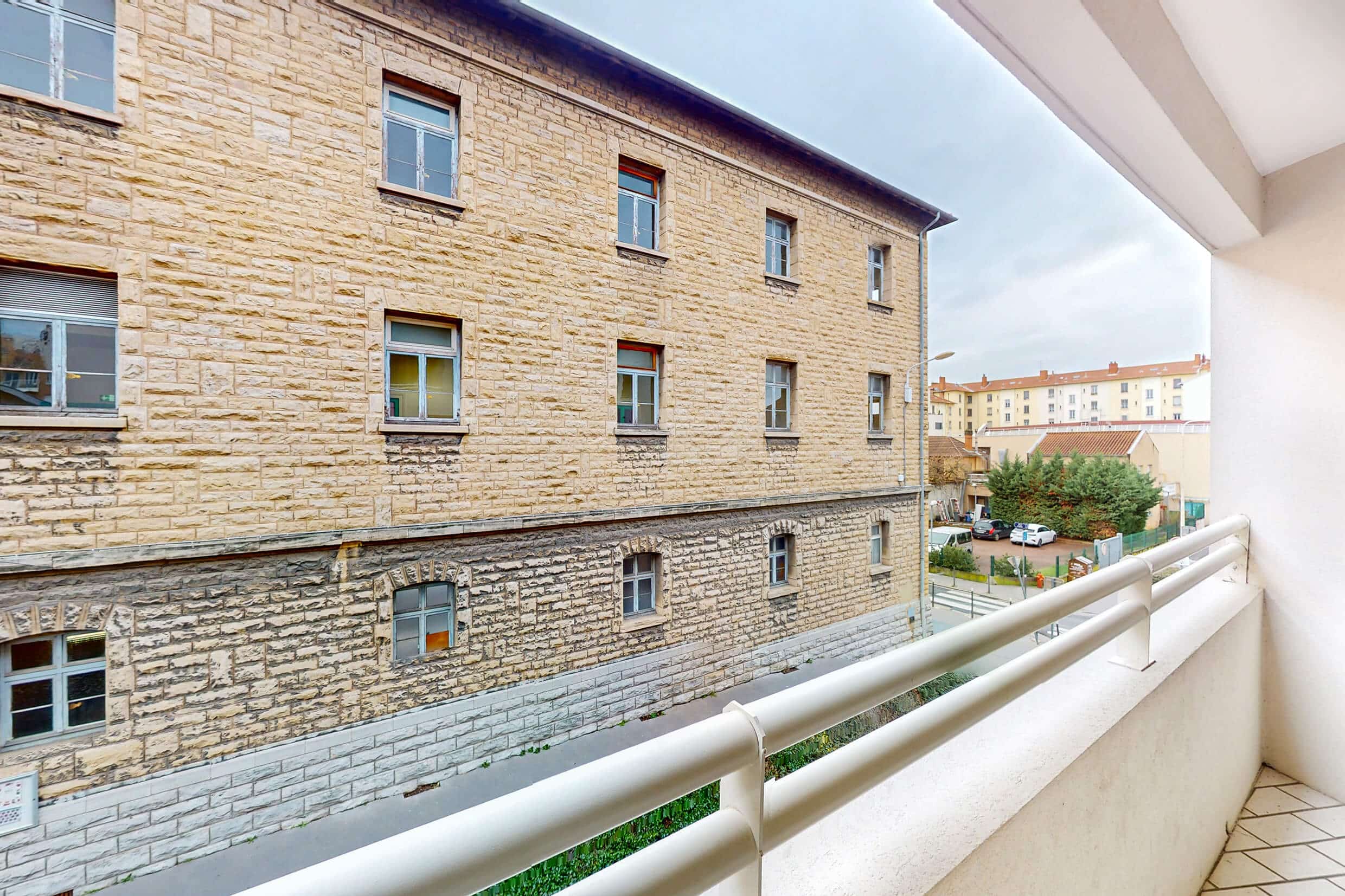 Balcon avec vue dégagée sur les bâtiments en pierre de Montchat, appartement vendu par Solenne Legros