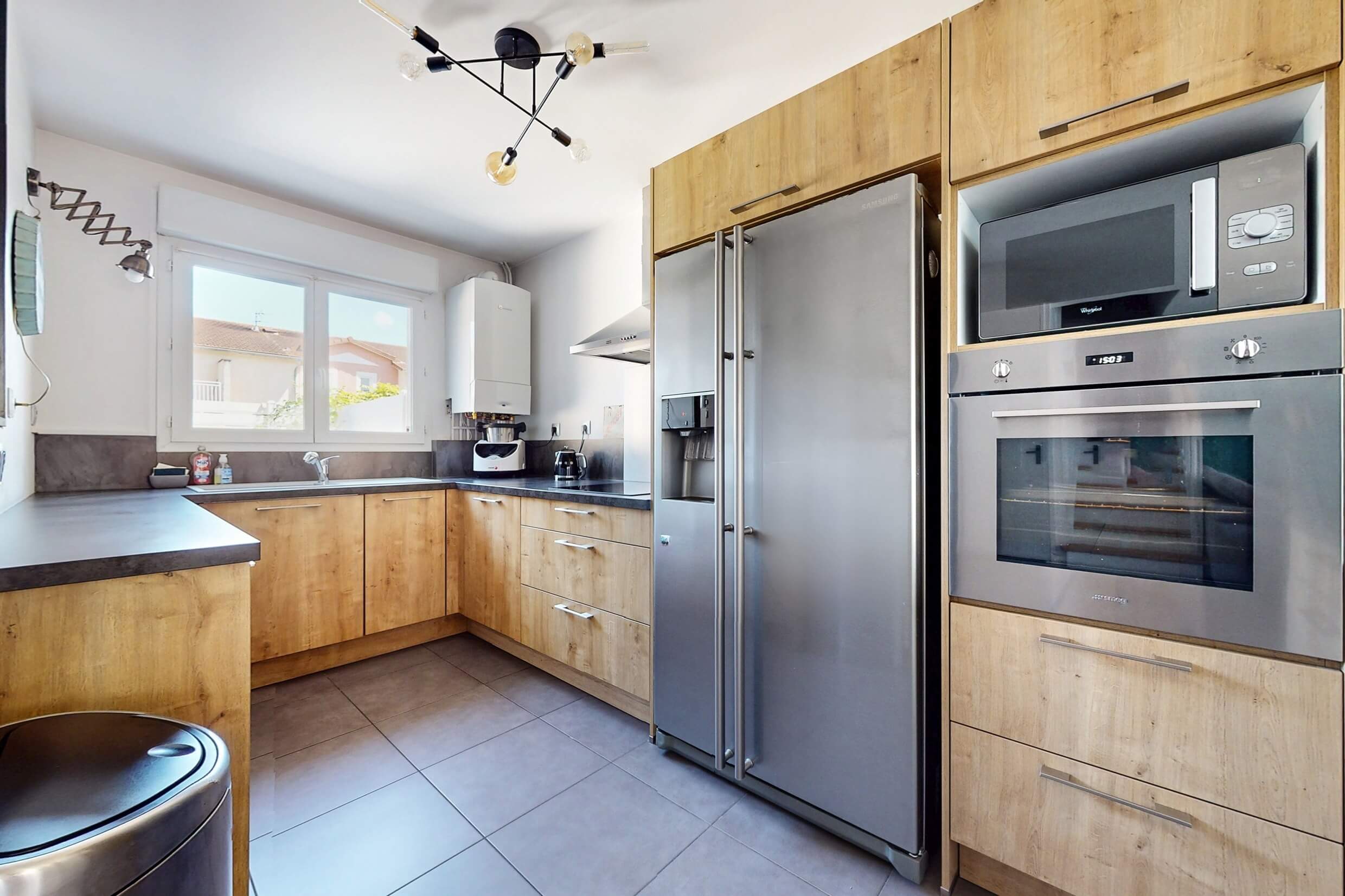 Cuisine moderne et rénovée ouverte sur le séjour d’une maison de ville à Genas
