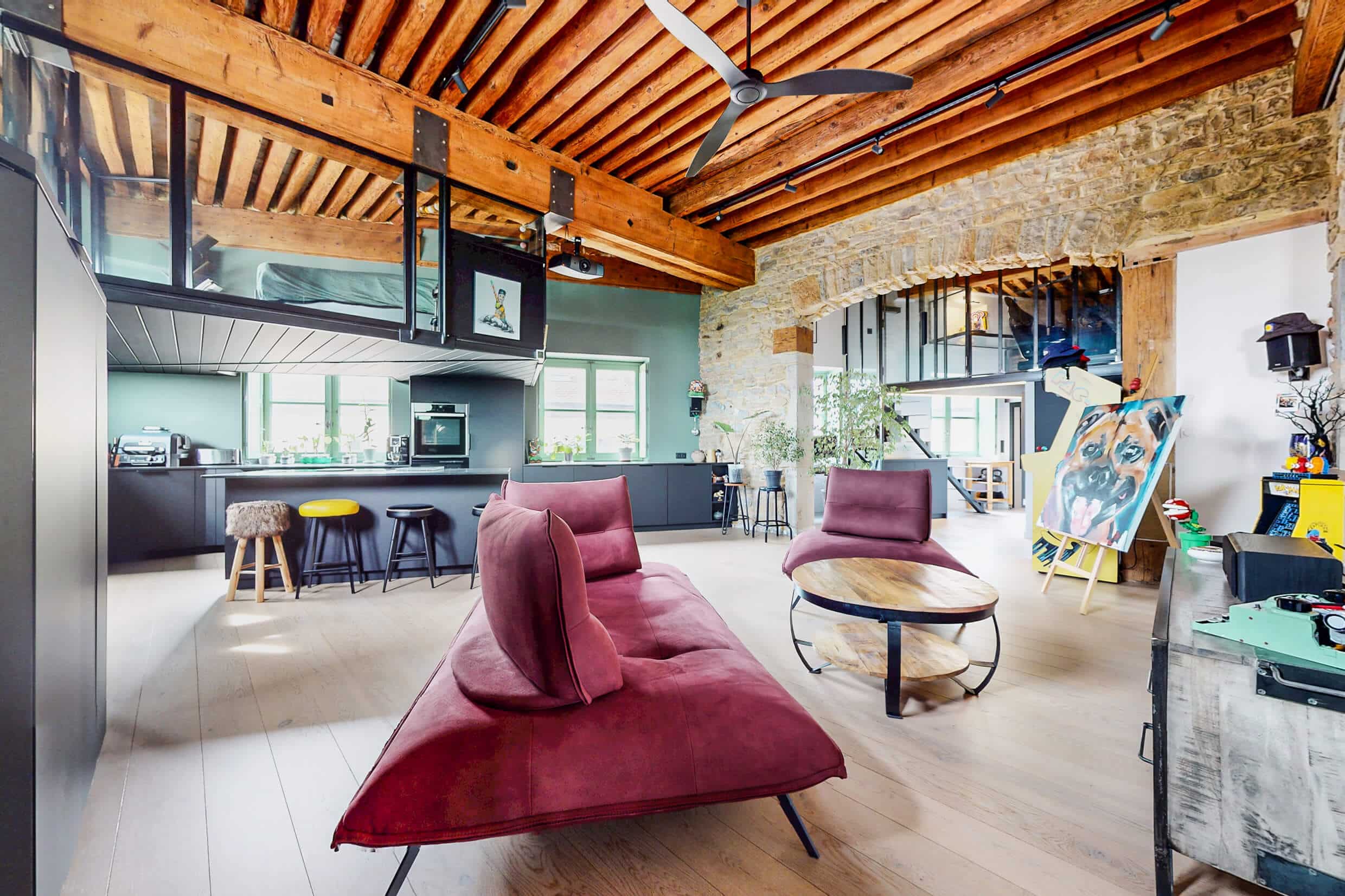 Pièce de vie du loft à Lyon 4e avec cuisine ouverte, poutres apparentes et esprit canut.