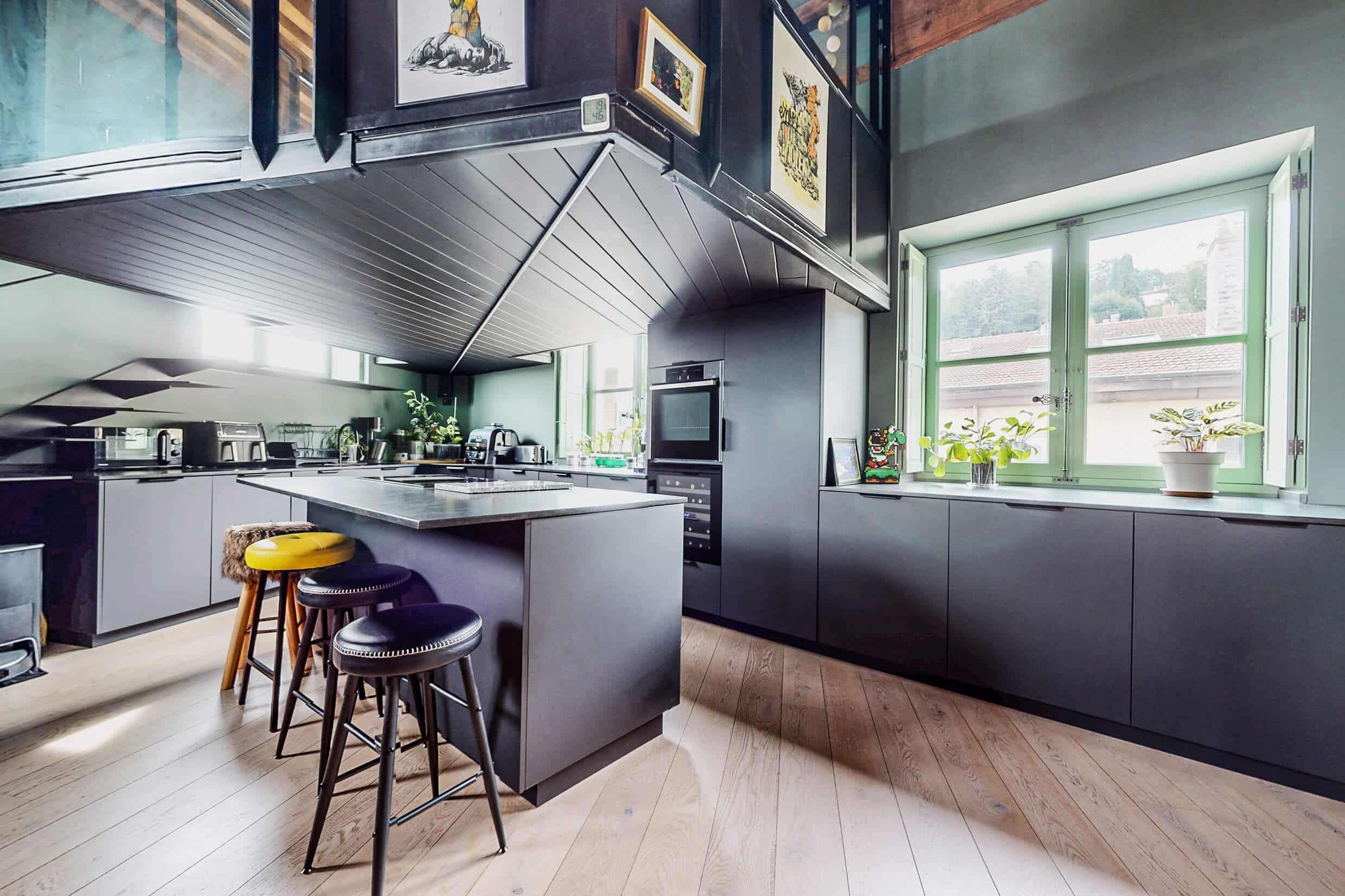 Cuisine noire style industriel conçue par un architecte dans un loft à Lyon 4ᵉ.
