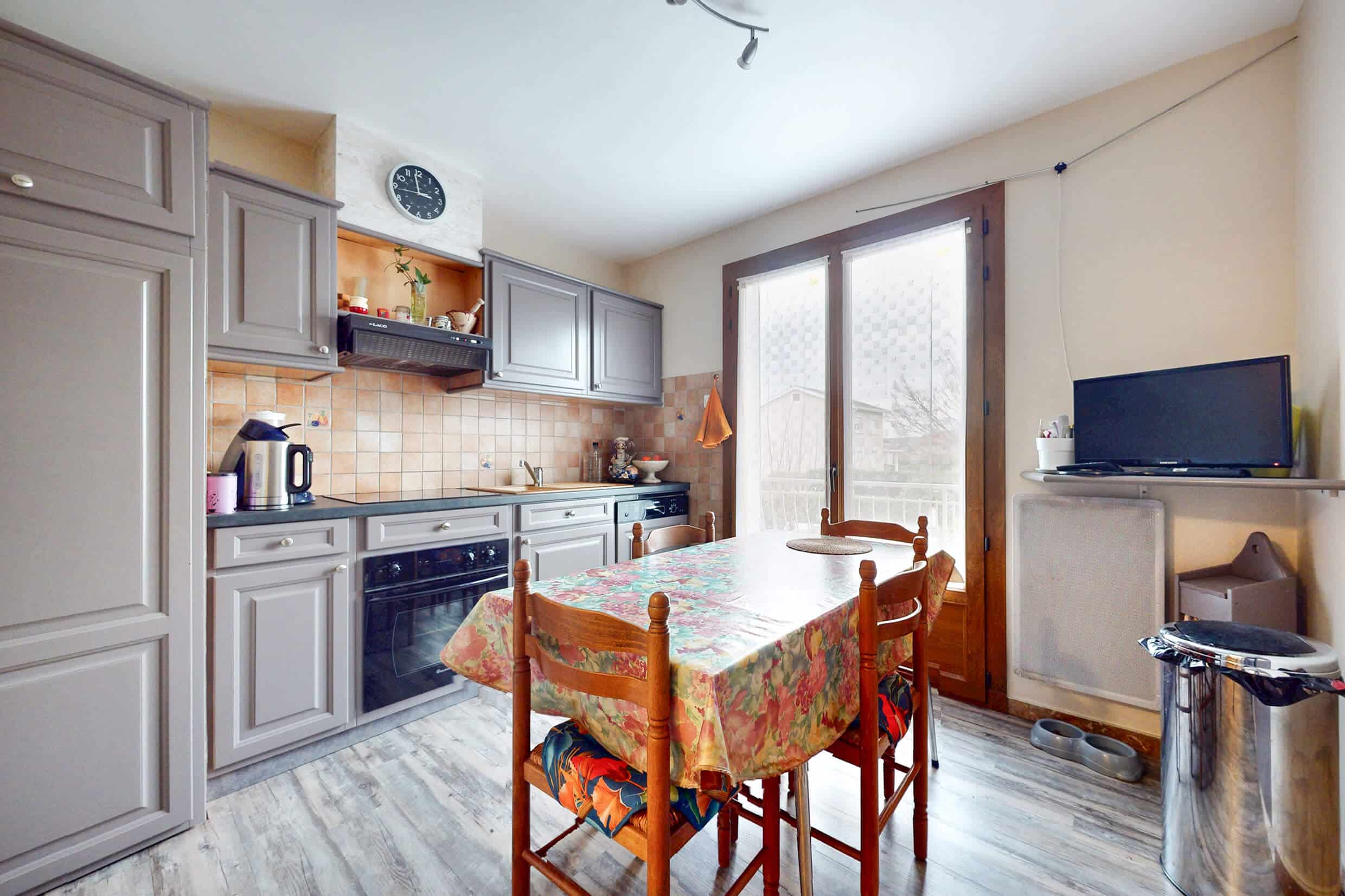 Cuisine séparée avec accès balcon dans une maison familiale à Corbas