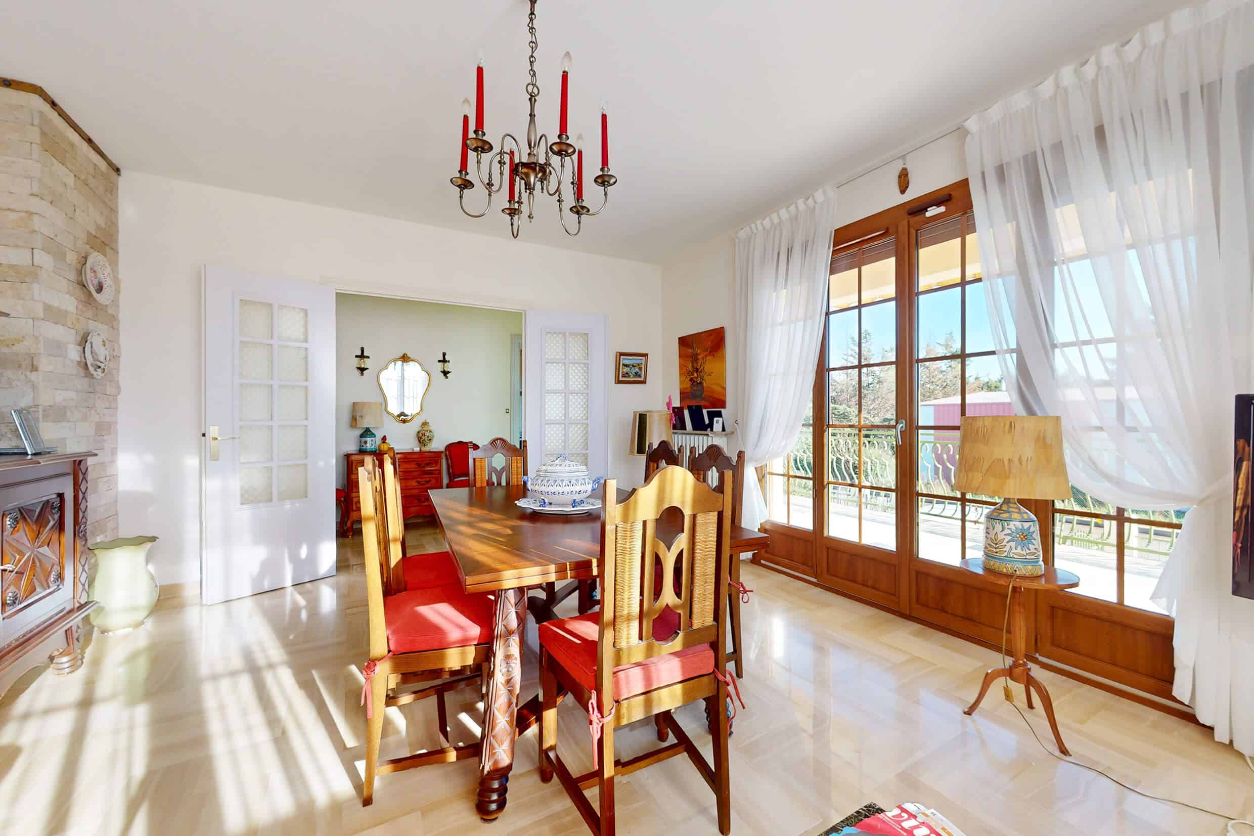 Salon lumineux d’une grande maison familiale à Pusignan avec accès direct à un grand balcon