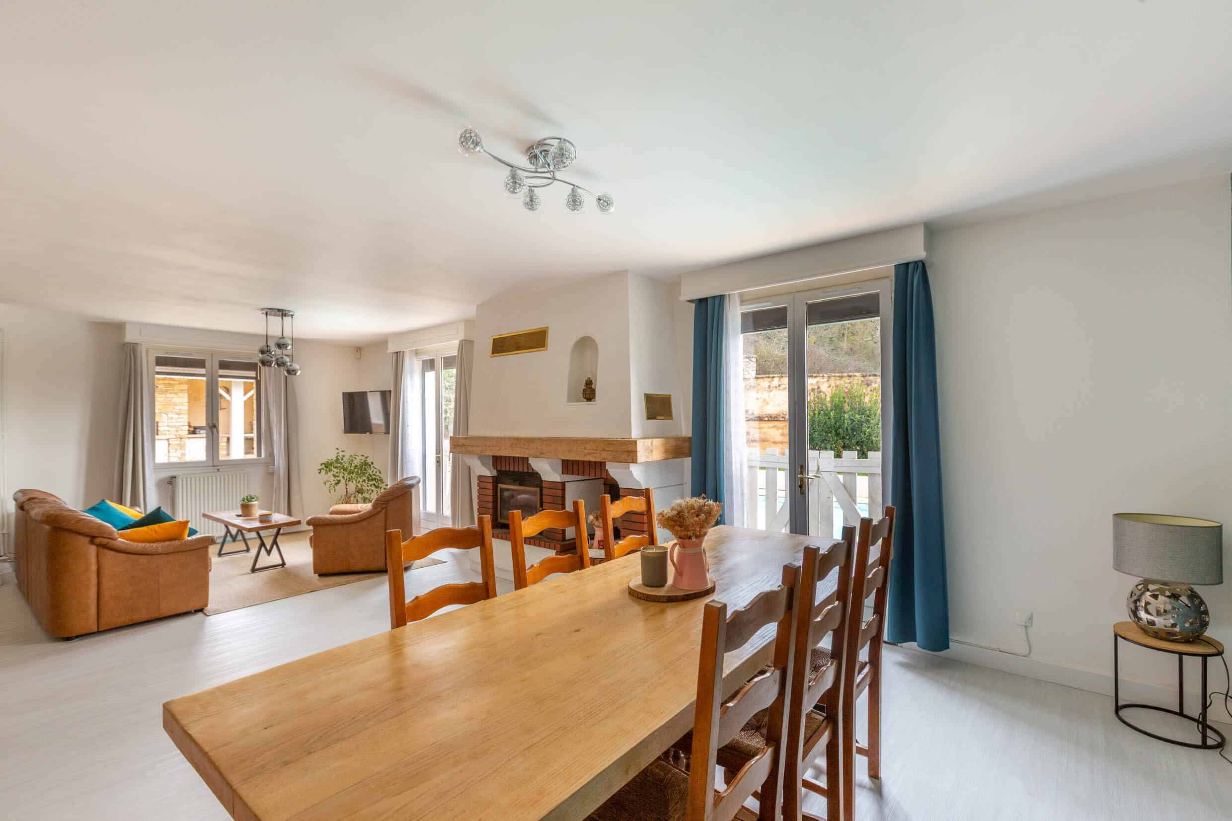 Grande pièce de vie avec cheminée et cuisine ouverte dans une propriété en pierre à Saint-Marcel-Bel-Accueil